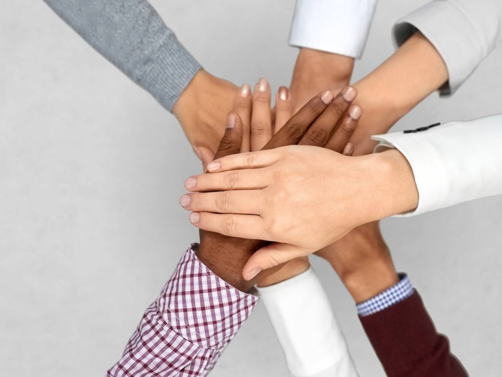diverse business team putting hands together